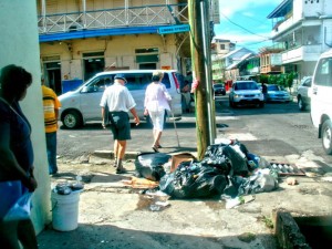 Tourists from a cruise ship walk around garbage in Roseau
