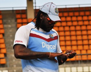 Chris Gayle clips his fingernails before practice at the Windsor Park on Monday