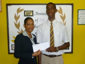 Dominica Grammar School student Anil Chambers receives a cheque from Suzanne Joseph Piper presents cheque to Anil Chambers Suzanne Joseph-Piper of NBD