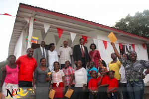 Recipients and officials pose in front one of the new houses