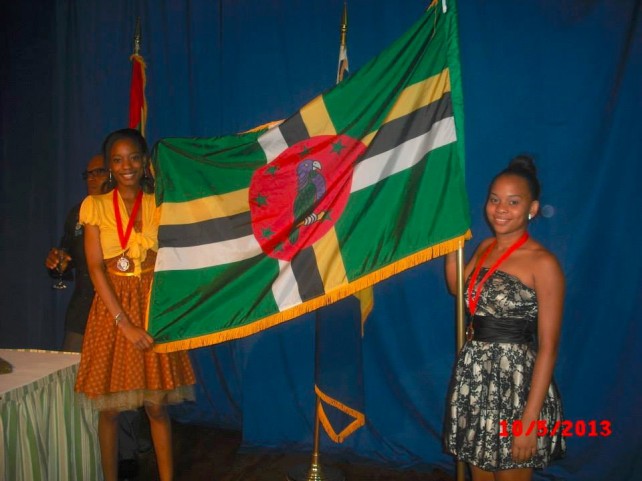 Zawadi Warner (right) and Mitra Morancie with the flag of Dominica and their medals around their necks at the competition 