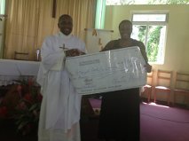 Adelaide Paul presenting Fr. Herman Sharpliss with a $5,000 US check donation from NYPRCCRI. May 5th 2013