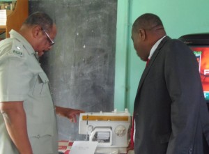 Supt. Blanc and AID Bank boss examines the sewing machine donated on Thursday
