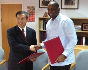 PM Skerrit shakes hands with Ambassador Wang after signing the grant agreement