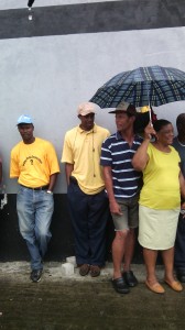 Striking public works employees braving the rain outside the company's office. 