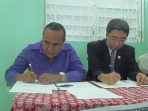 DAPD Executive Director, Nathalie Murphy and Japanese Deputy Head of  Mission Hirofumi Murabayashi sign contract documents for muliti-purpose development center