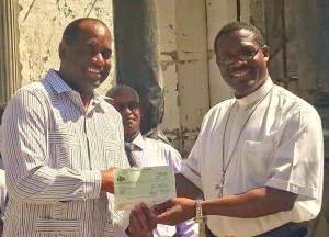 PM Skerrit presented the check to Bishop Malzaire on Wednesday morning 