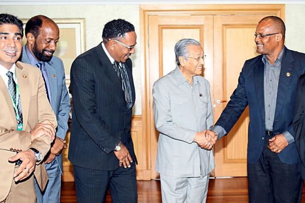 Nanthan shakes hands with Dr. Dr Mahathir as members of the Dominican delegation look on. Photo credit: The Star Online
