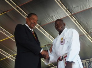 Robin shakes hands with president Charles Savarin after receiving the award 