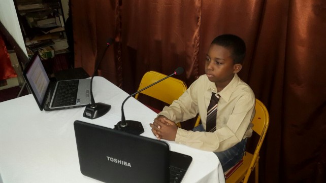A Berean Christian Academy student playing the role a broadcaster in a Christmas presentation