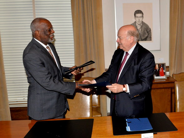 Dominica's ambassador to OAS, Charles shakes hands with Insulza after signing the agreement
