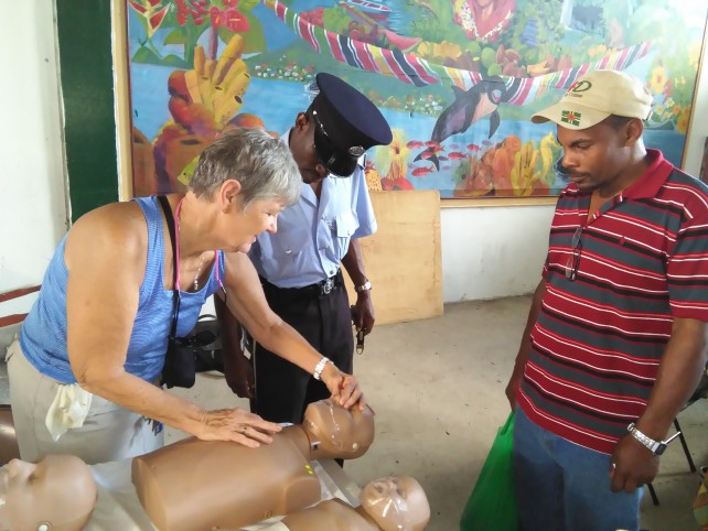 Patty Rennels demonstrates CPR to policeman and passerby.