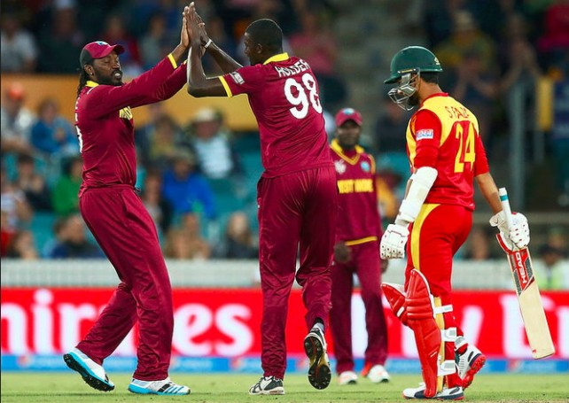 Gayle (left) celebrates a wicket at the match