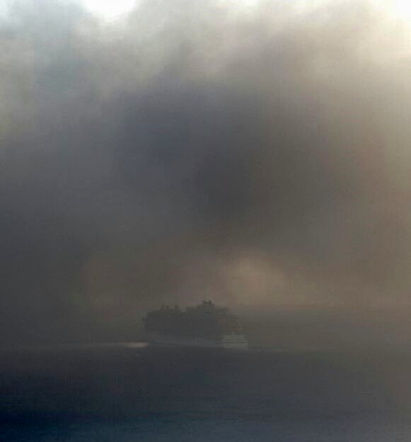 The ship enveloped by smoke leaves port earlier on Friday 