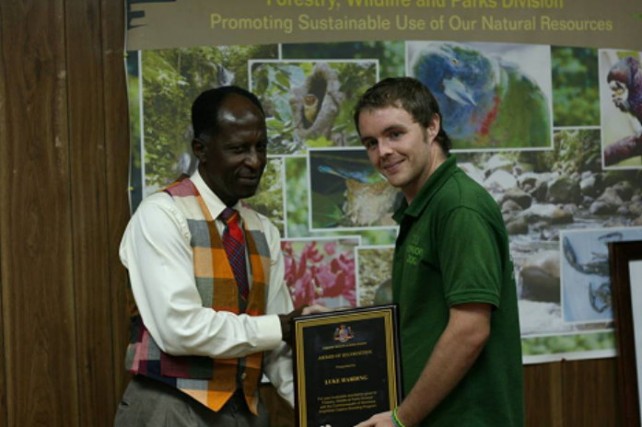 Luke Harding receives a plaque for his work on the Mountain Chicken Project 