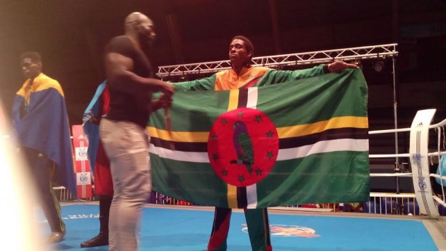 Leatham holds the flag of Dominica after his record knock out in Martinique 