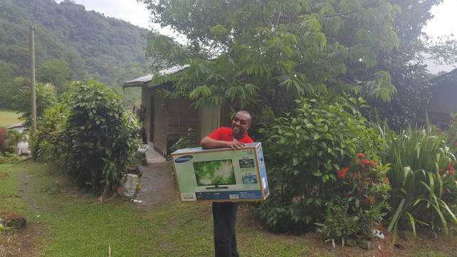 Digicel's Sales Representative Lincoln Cassell approaches Casey's home with Flat Screen TV