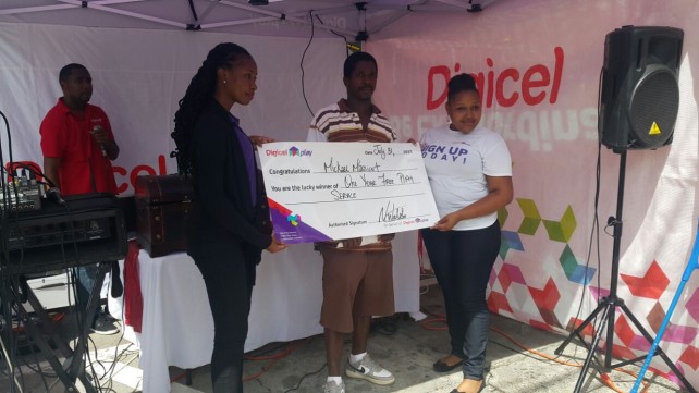 Lucky winner of one year free service Mickael Masicot - centre with Digicel Play Reps