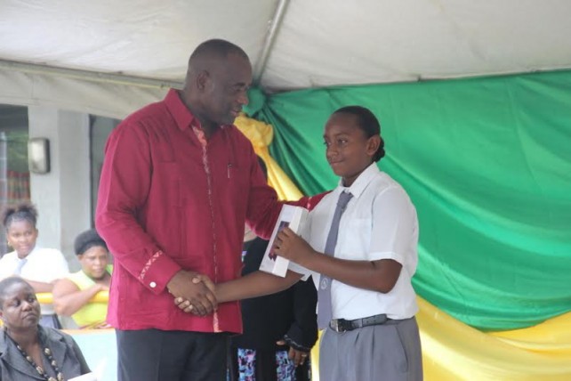 PM Skerrit hands over a tablet to a student