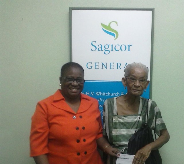  Ervinia Jolly receiving her insurance claim settlement from Ms. Beaupierre of Whitchurch Insurance