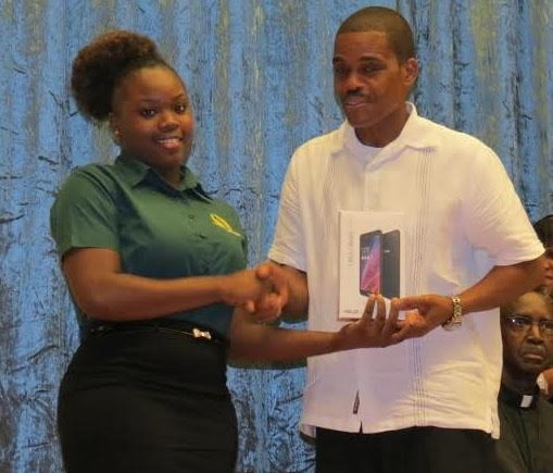 A college student receives her tablet from Education Minister Petter Saint Jean 