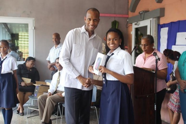 A student receives her tablet from Darroux 
