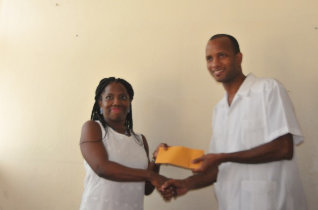 Ag. Education Minister Darroux receives cheque from Parkinson Memorial School Teacher
