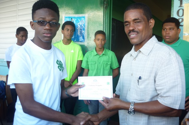 Saint Jean (r) presents a certificate to a student