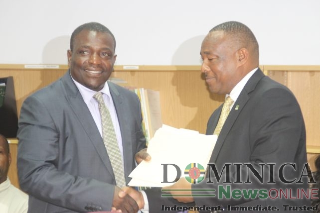 Agriculture minister Drigo shakes hands with AID Bank's Board of Directors Chairman, Martin Charles
