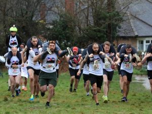 Participants compete for barrel of ale in wife-carrying race in UK